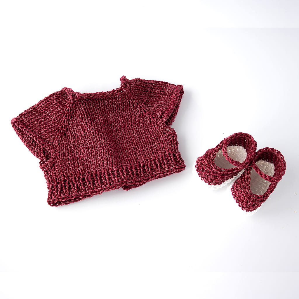 Handgestrickter Puppenpullover in Bordeaux mit kurzen Ärmeln und dazu passende gehäkelte Schuhe