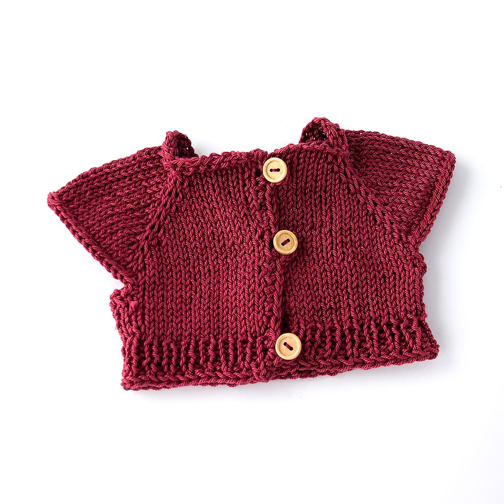 Rückseite des gestrickten Puppenpullovers mit Holzknöpfen für einfaches Anziehen
