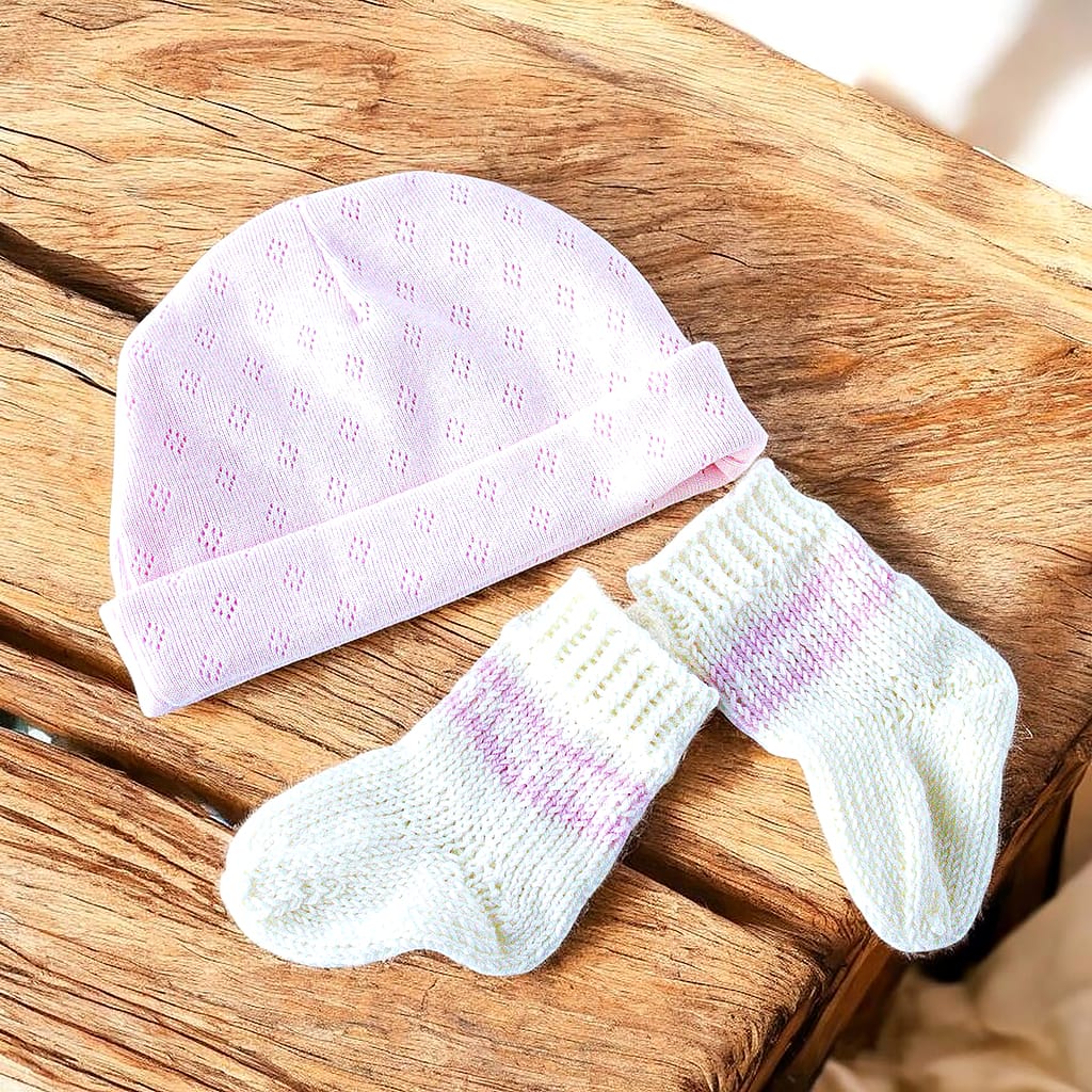 Babymütze mit feinem Lochmuster in Rosa & handgestrickte Söckchen in Weiß mit zartem Muster in Rosa