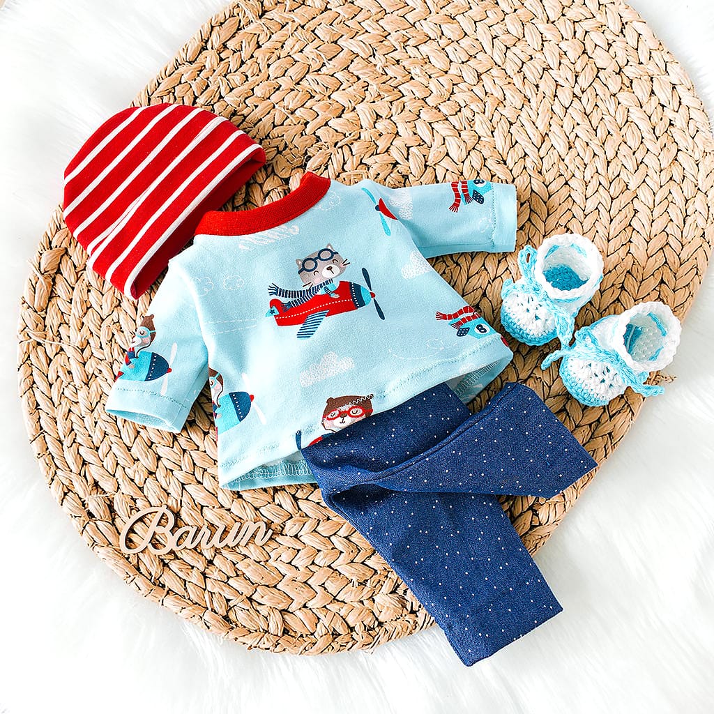 Handgemachtes Puppenset für Waldorfpuppen mit hellblauem Shirt mit Fliegerkatze, dunkelblauer Hose, rot gestreifter Mütze und gehäkelten Schuhen