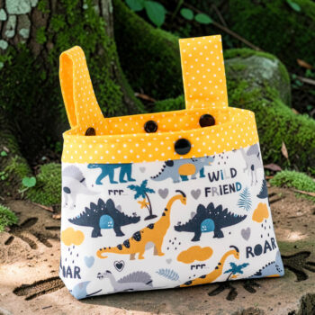 Kleine Kinder Lenkertasche mit Dinosauriermotiv und verstellbaren Befestigungsschlaufen auf einem Waldweg