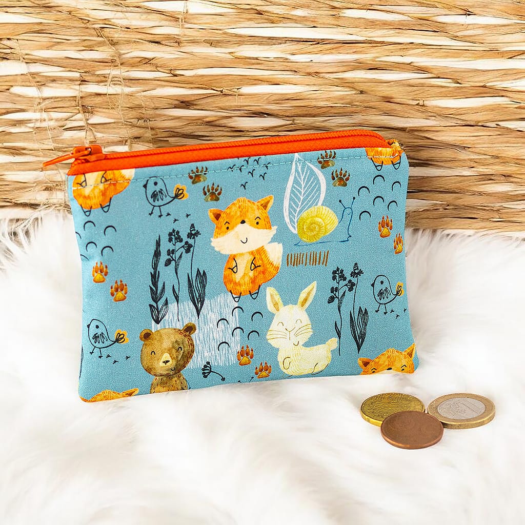 Kleine Kindergeldbörse mit Fuchs, Hase und Bär auf hellblauem Stoff und orangem Reißverschluss