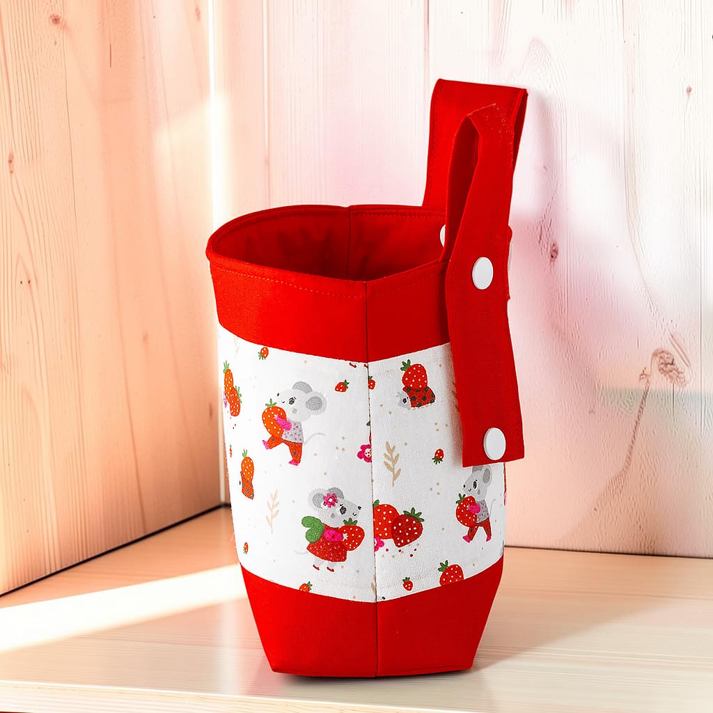 Seitenansicht der Erdbeermaus-Lenkertasche mit rotem Boden und Druckknopf an der Befestigungslasche.