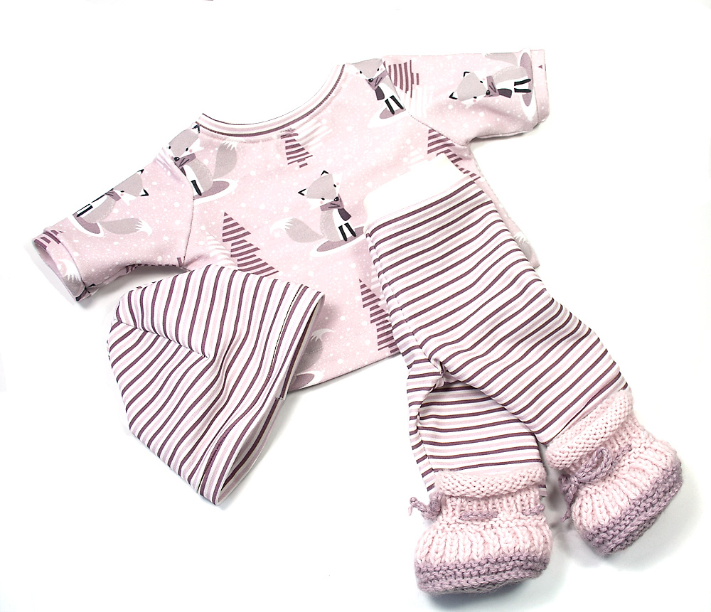 4-teiliges Puppenkleidungs-Set mit Fuchs-Pullover, gestreifter Hose, Mütze und gestrickten Puppenschuhen auf hellem Hintergrund