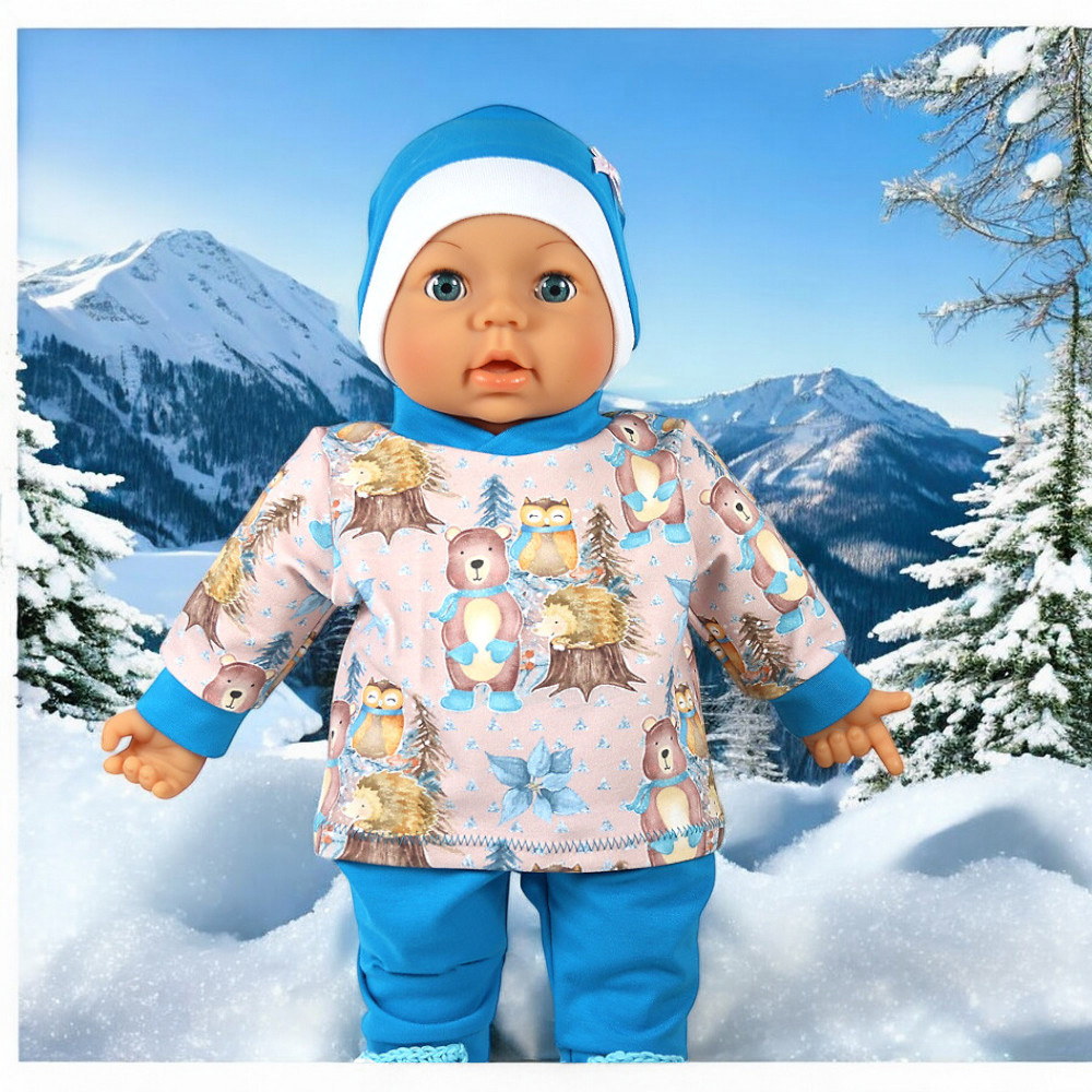 4-teiliges Puppenkleidungs-Set für Babypuppe mit Wintertier-Pullover, blauer Hose und passender Mütze im Schnee fotografiert