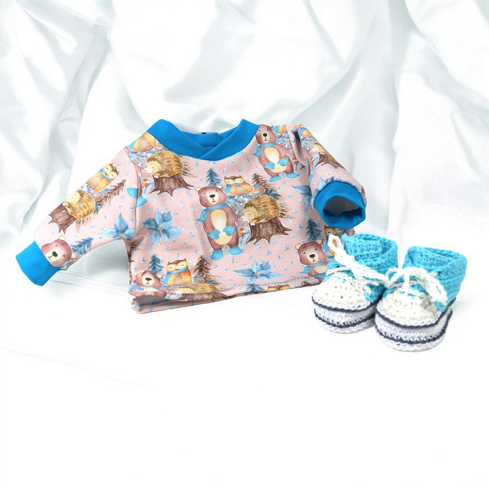 Puppenkleidung für 43 bis 46 cm Babypuppe mit Wintertier-Motiv und handgehäkelten Schuhen auf hellem Stoffhintergrund
