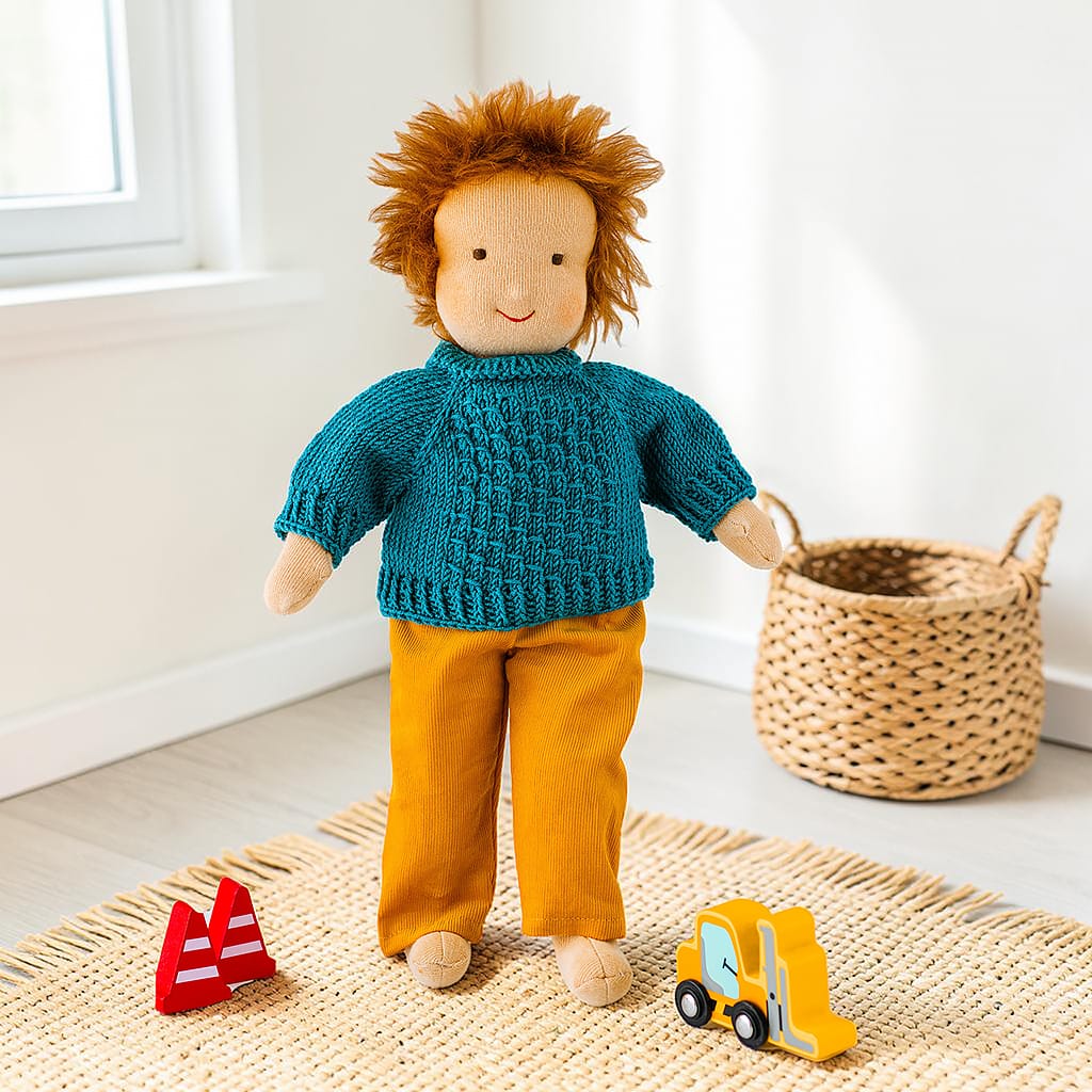 Waldorfpuppe trägt eine senfgelbe Babycordhose und einen petrolfarbenen Strickpullover. Die Kleidung ist für Puppen von 38 cm geeignet.