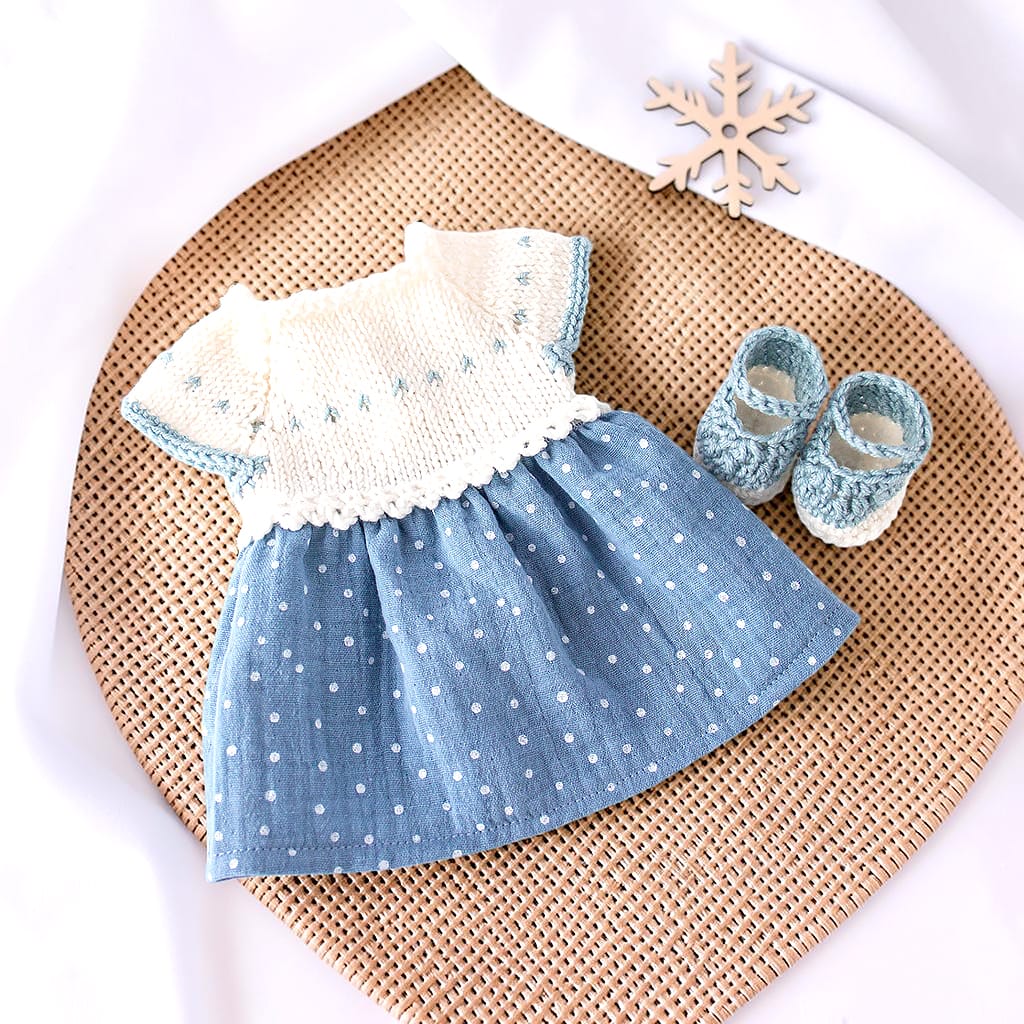 Puppenkleid für eine 32 cm Stoffpuppe mit weißem Merinowoll-Oberteil und blauem Musselinrock mit weißen Punkten, daneben passende Schuhe