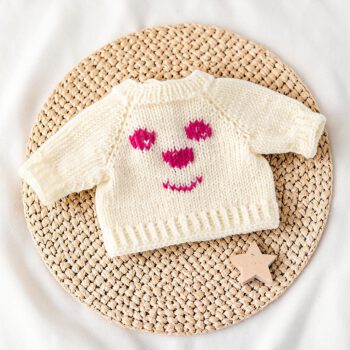 Weißer handgestrickter Merinowollpullover für eine Waldorfpuppe mit aufgesticktem Bärengesicht