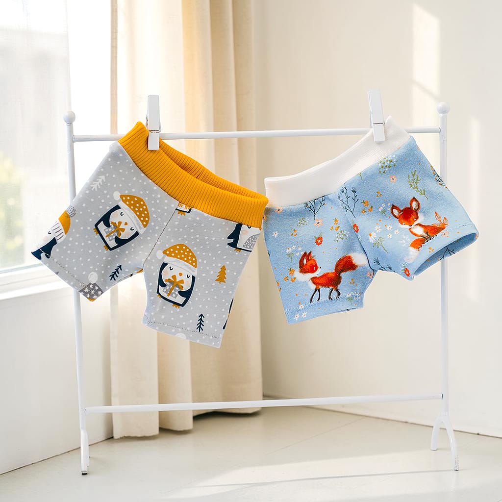 Boxershorts für Waldorfpuppen in zwei verschiedenen Stoffmustern mit Pinguinen und Füchsen